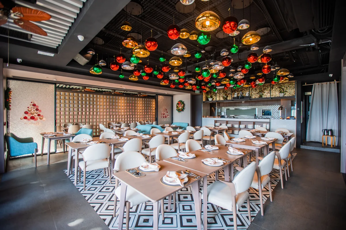 Inside Tagline, with colourful ceiling lights and tables ready for guests